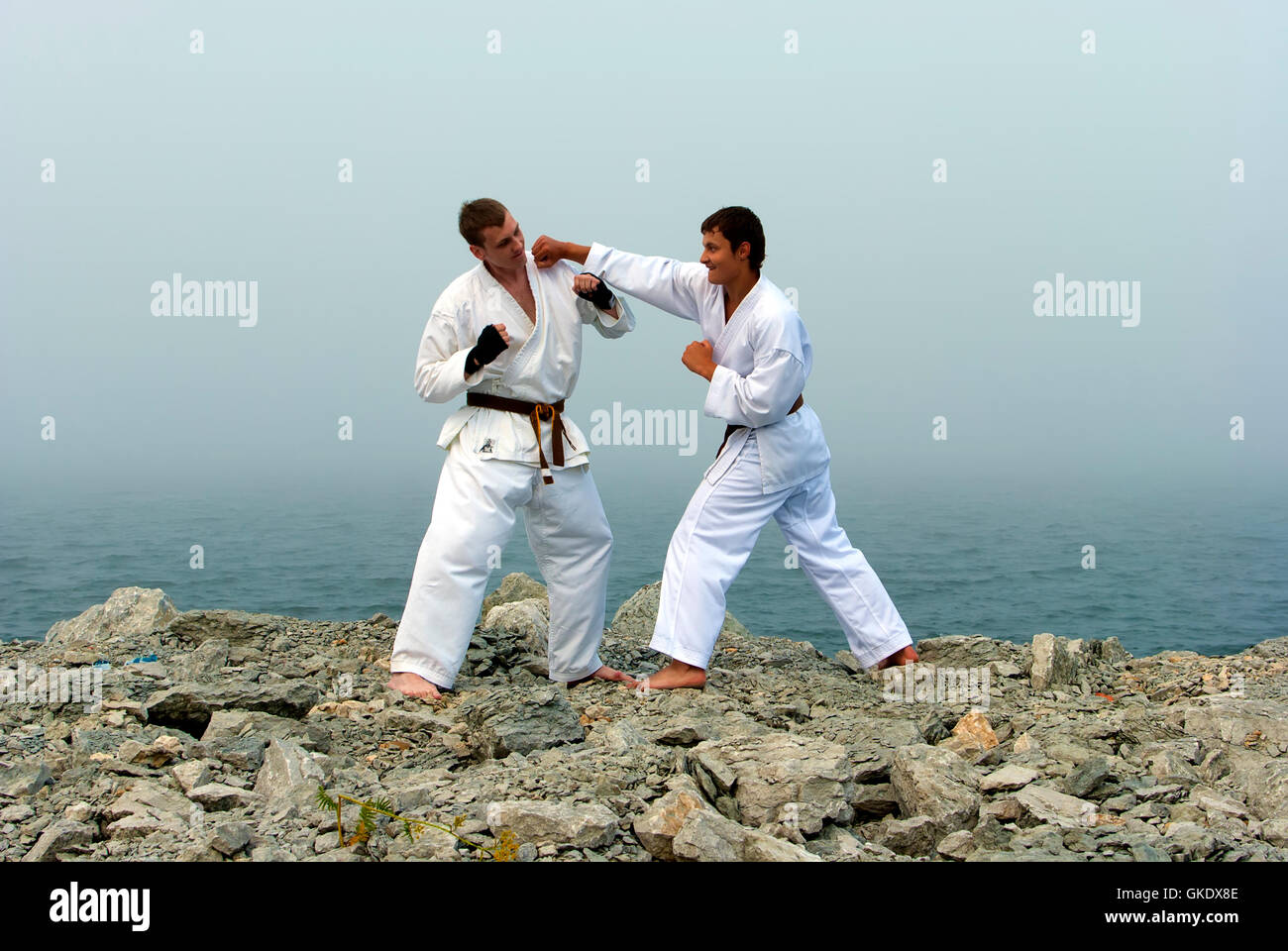two karateka fight on the banks of the misty sea Stock Photo Alamy
