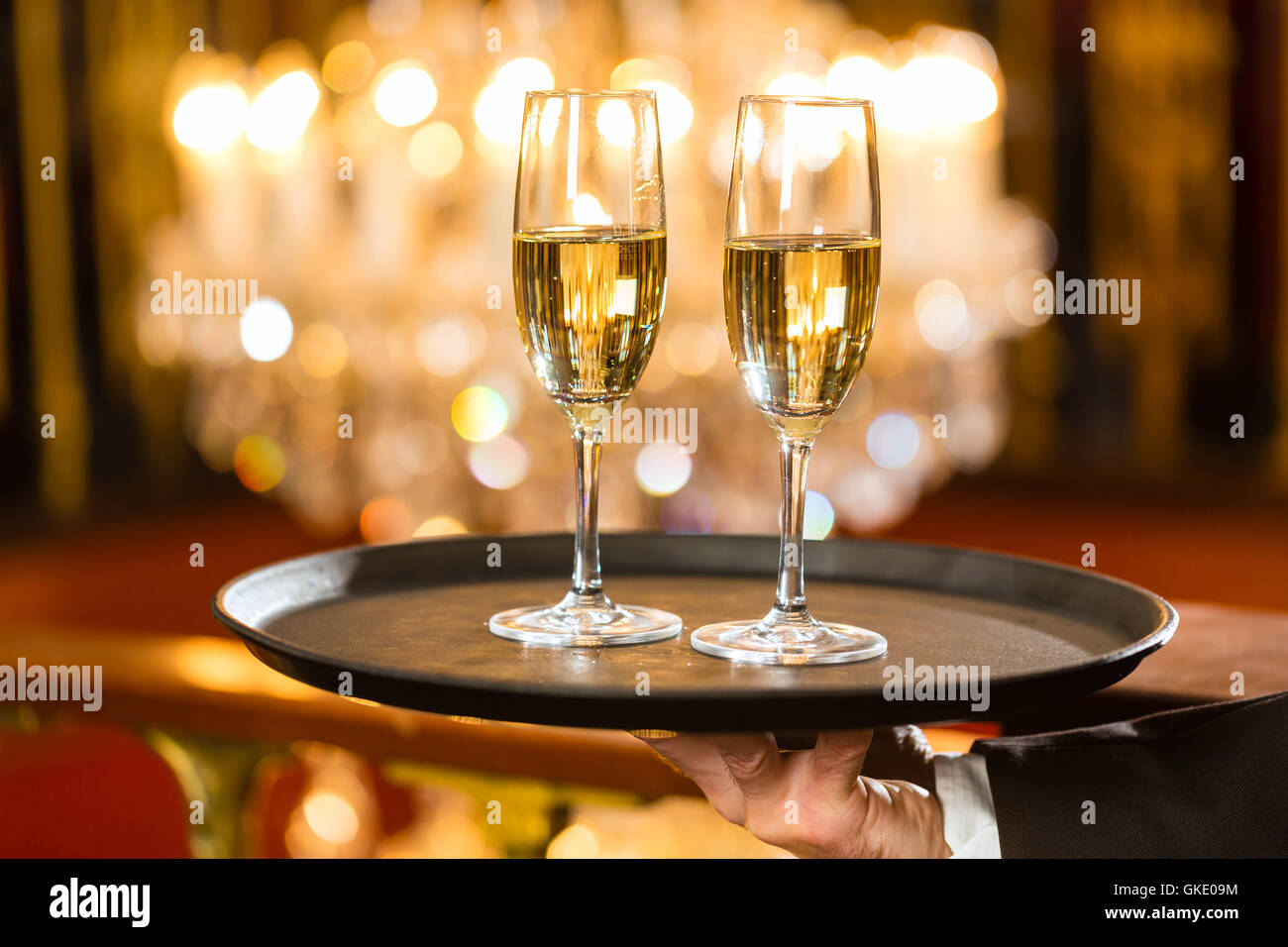 waiter serving champagne glasses on tray Stock Photo