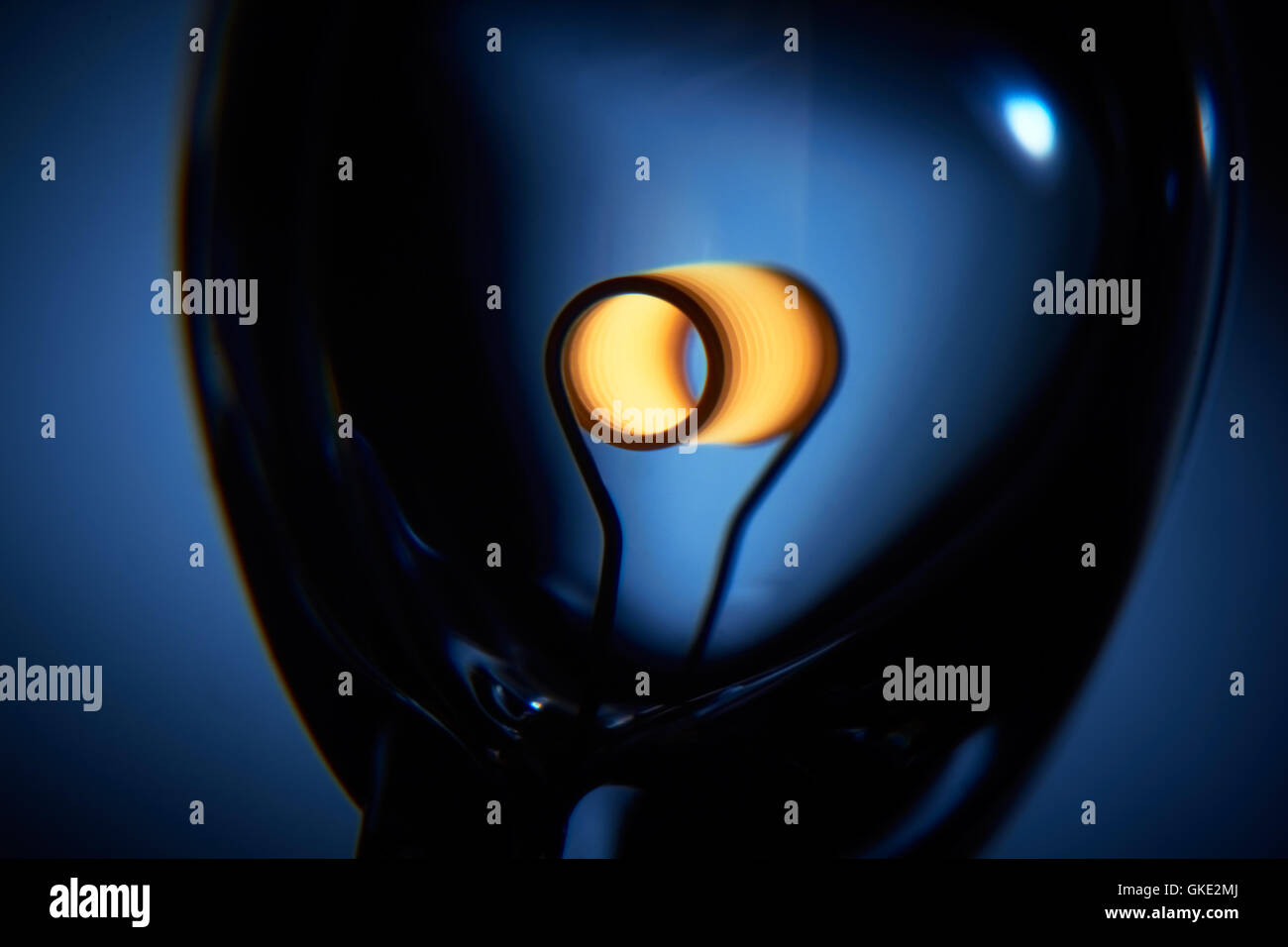 Glower is heated. Conceptual shot of incandescent lamp in blue. Stock Photo