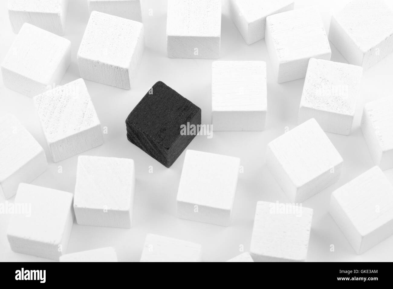 Black cube surrounded by white cubes Stock Photo
