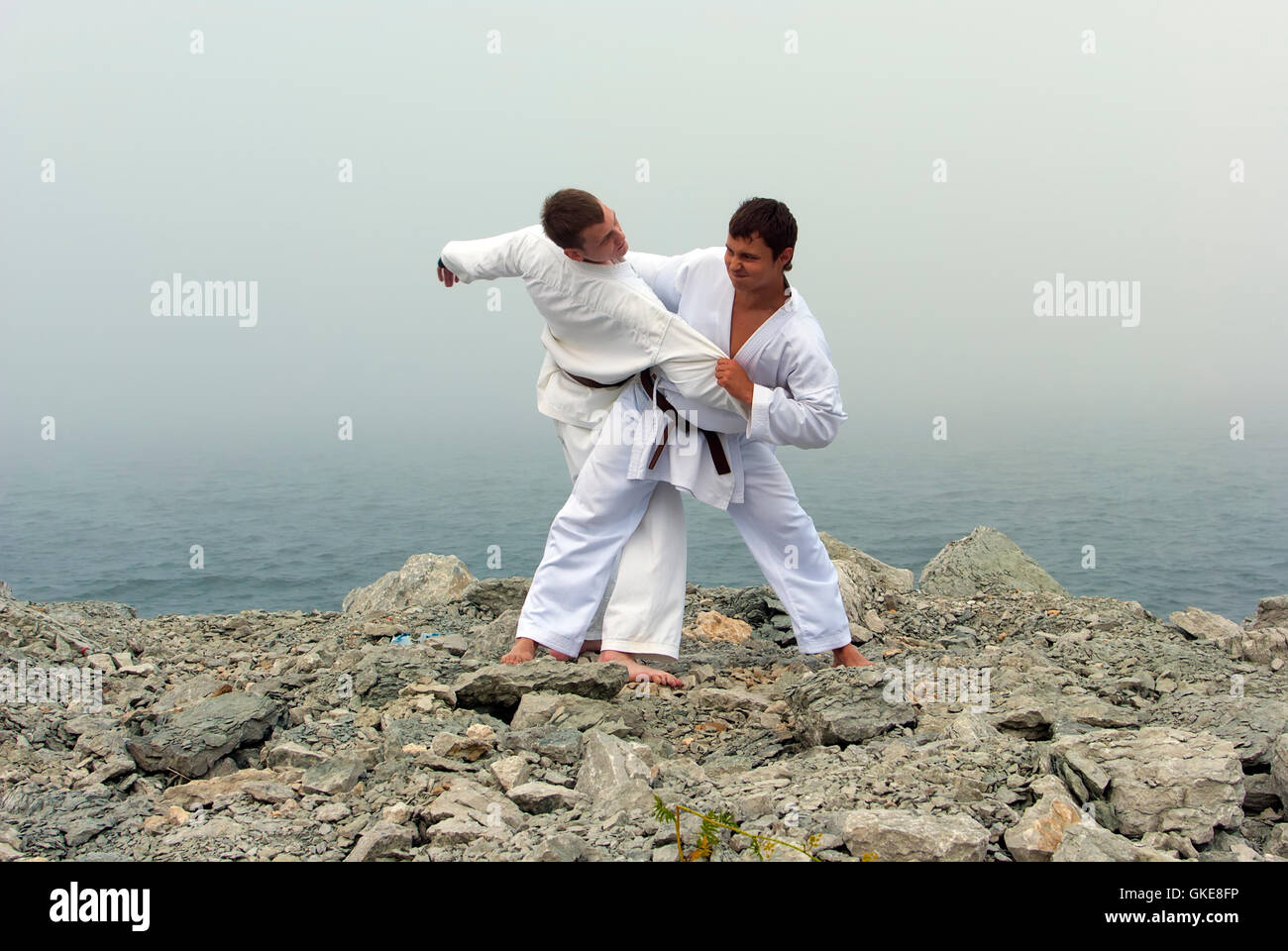 two karateka fight on the banks of the misty sea Stock Photo Alamy
