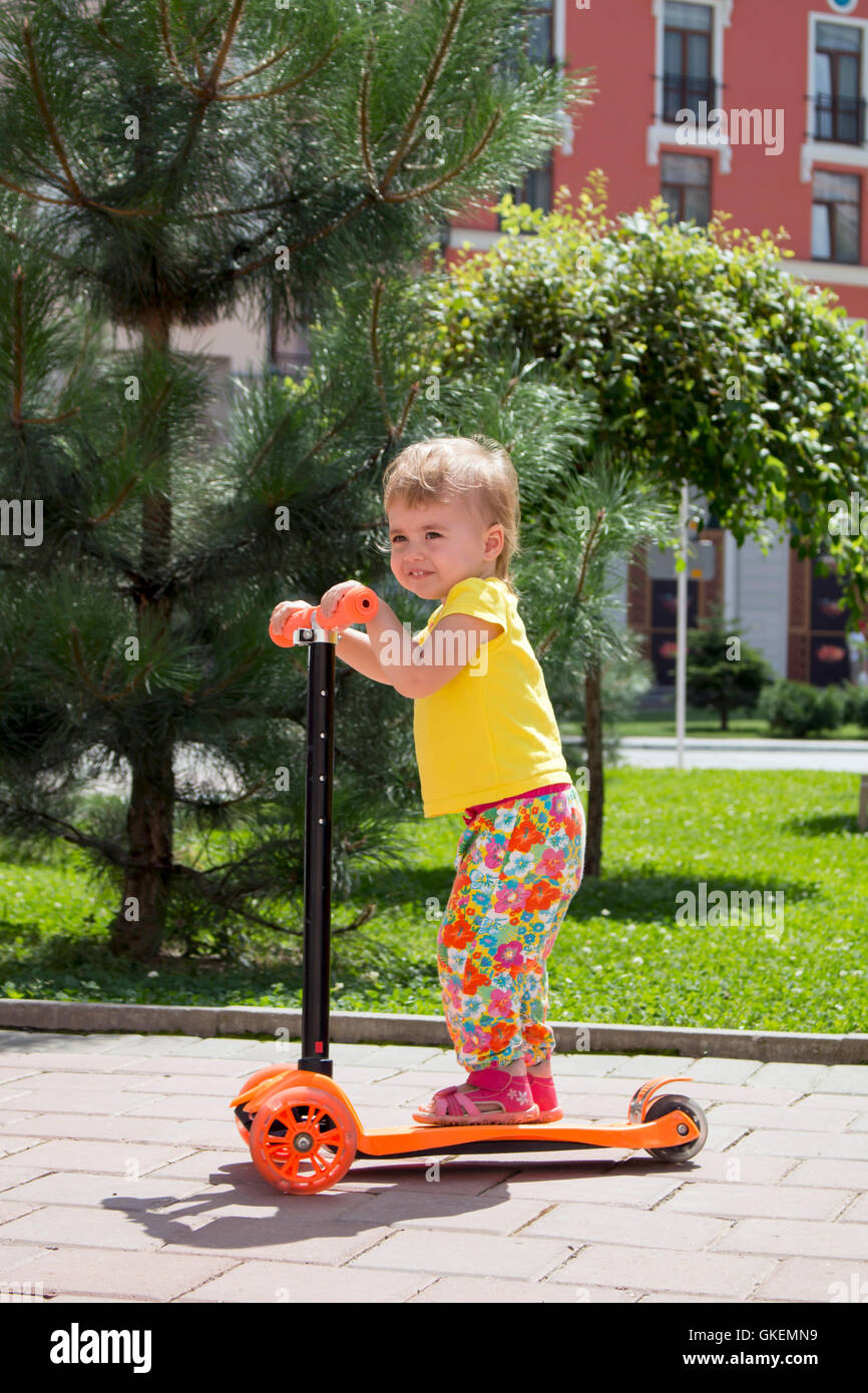 Two years old girl riding her scooter on the park Stock Photo Alamy