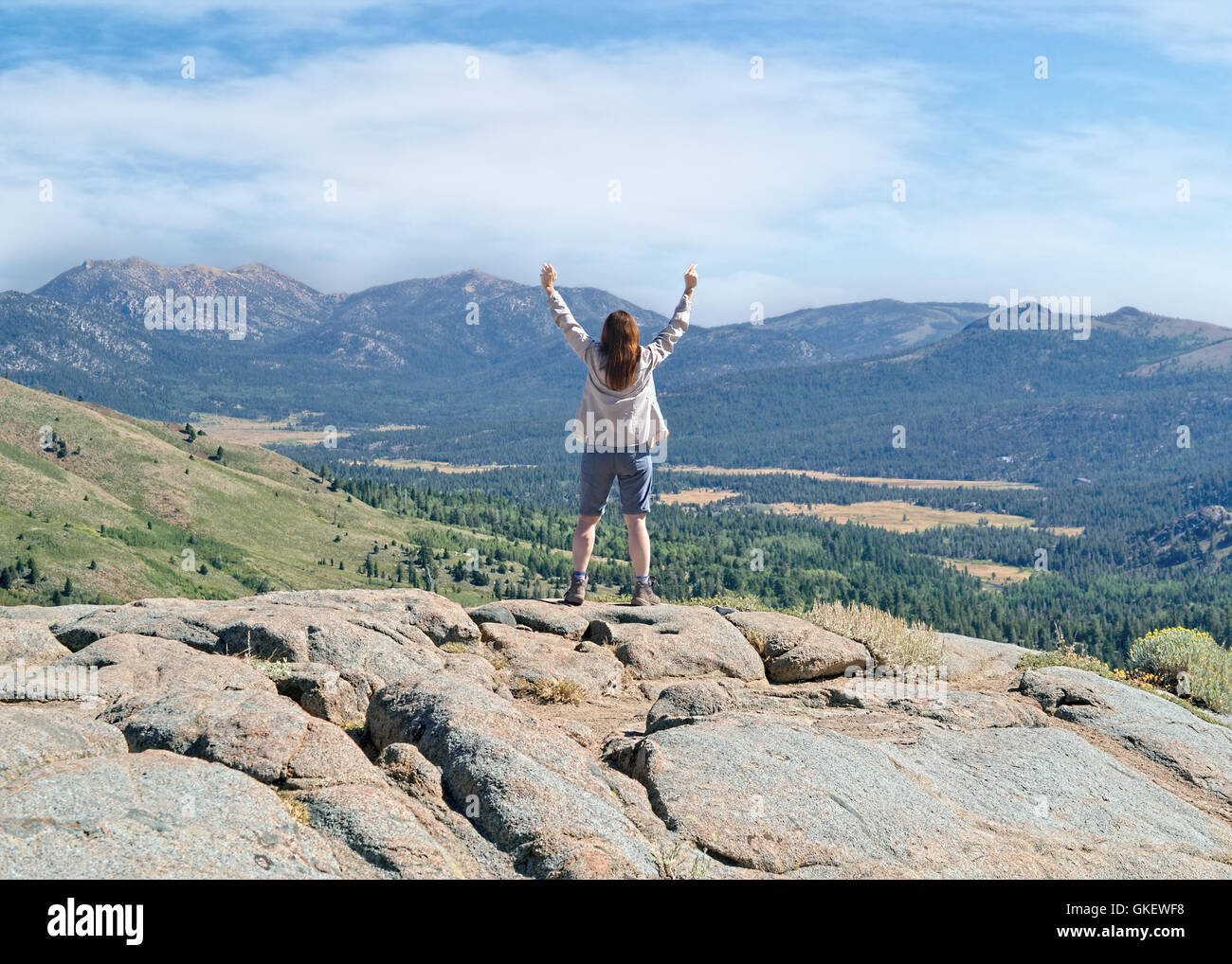 Middle-aged woman looking at canyon from Frog Lake overview, near Carson Pass at Sierra Nevada, California Stock Photo