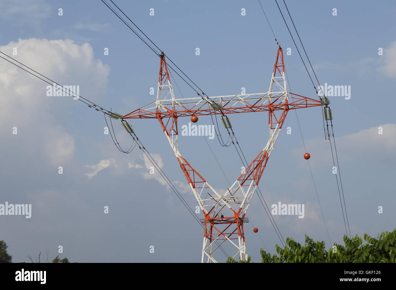 electricity transmission tower with blue skies and green trees Stock Photo