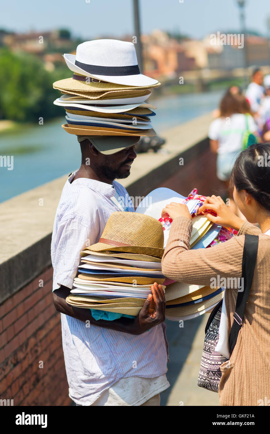 dark skinned man selling sunhats in Florence, Italy Stock Photo