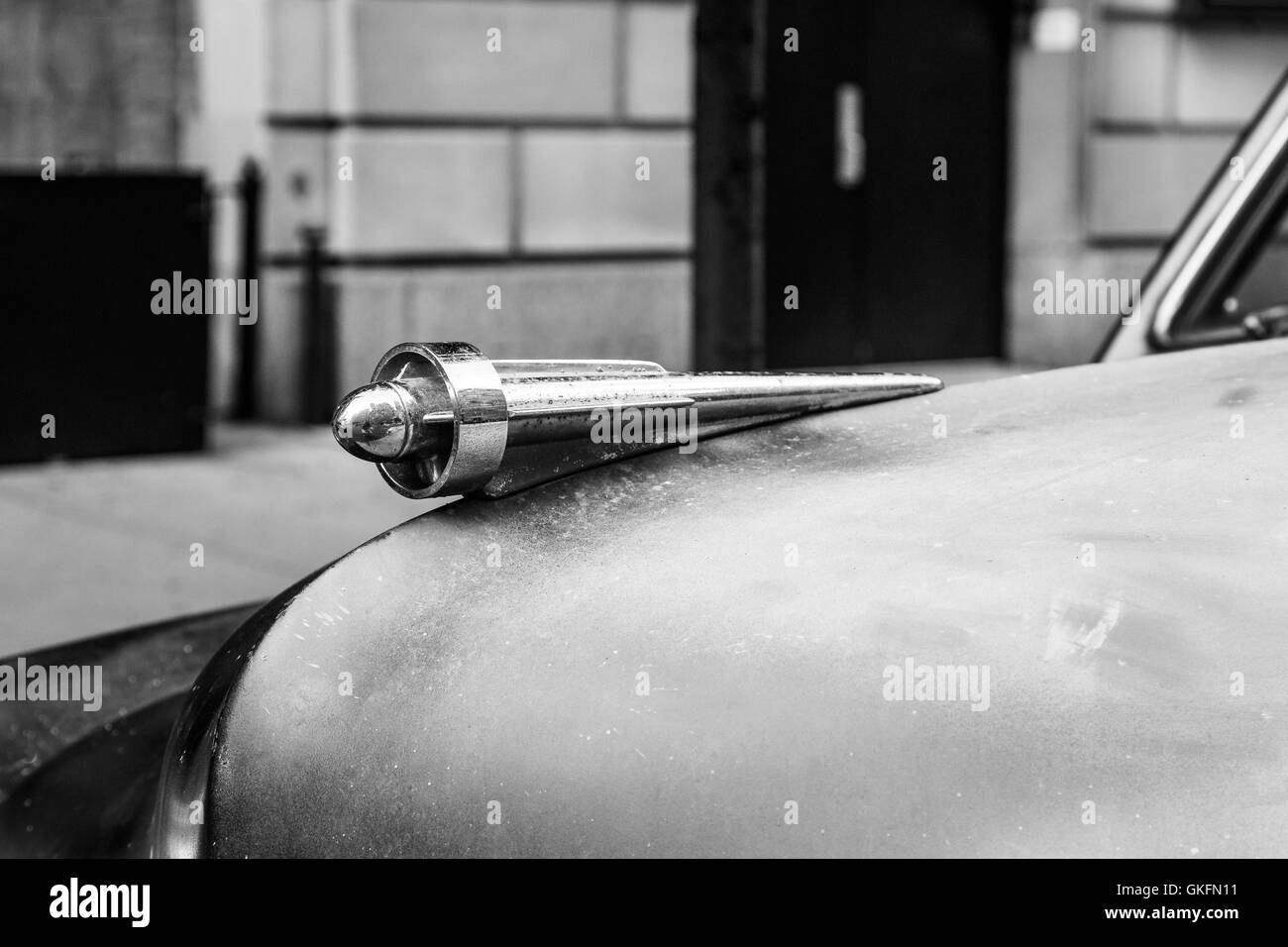 A chrome hood ornament on a vintage car that needs repair work. Stock Photo