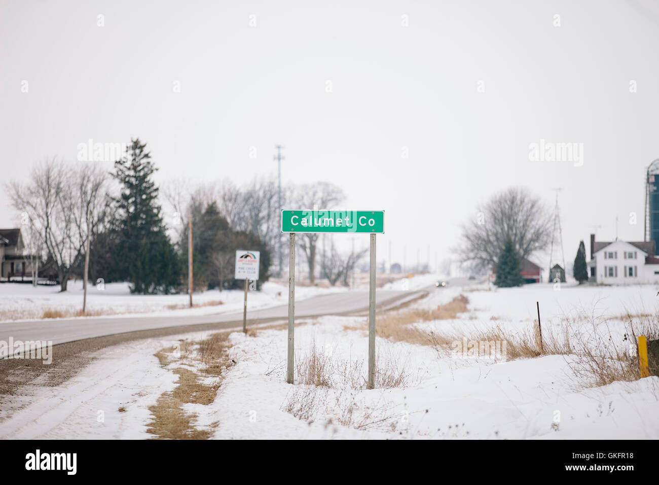 A Manitowoc County sign in the state of Wisconsin posted along a two lane highway. Stock Photo