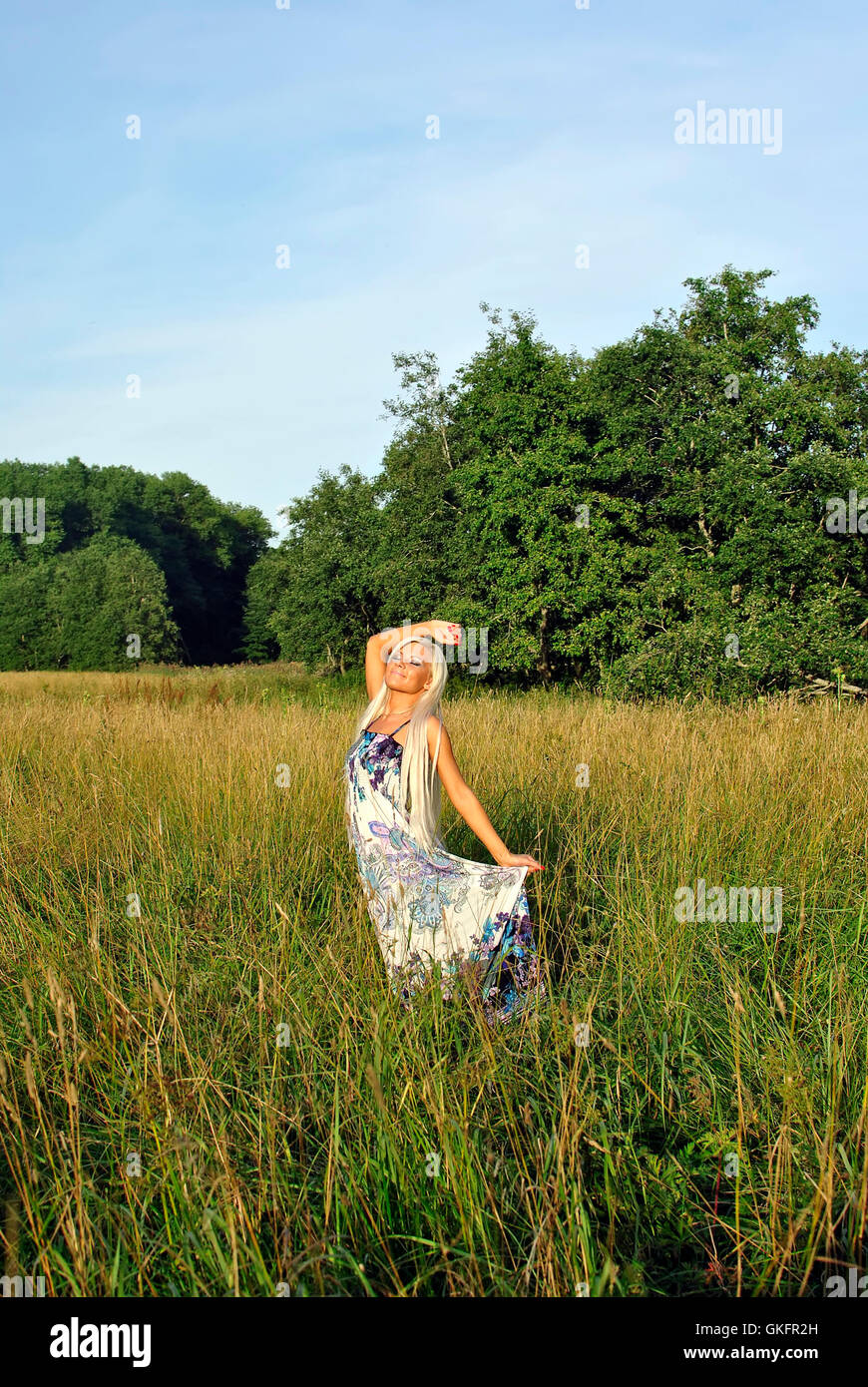Blonde girl alone in field. Stock Photo