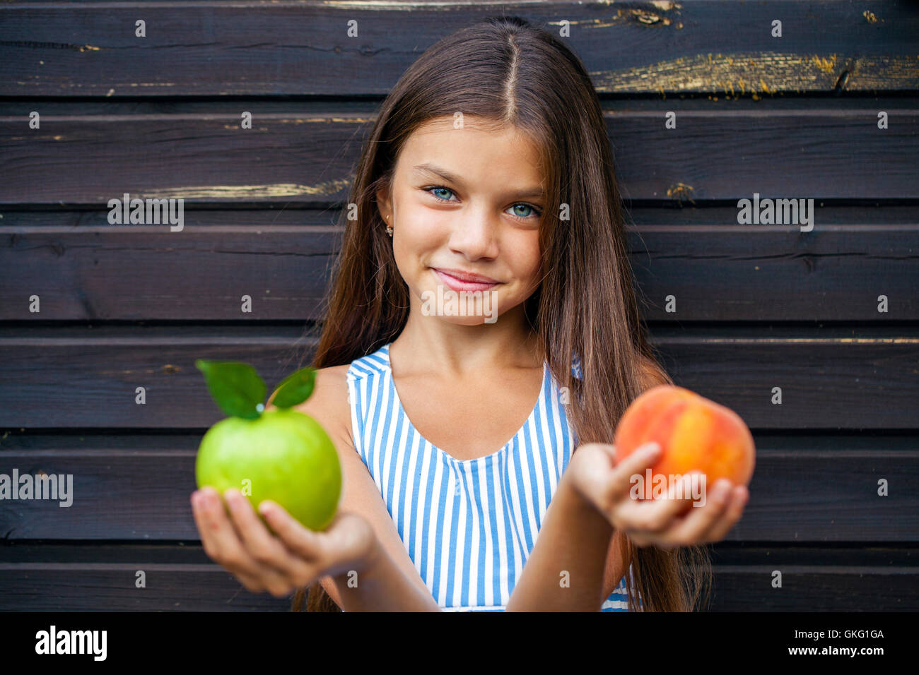 Девочка показала персик. Яблоко и апельсин в руках. Девушка держит яблоко. Девушка держит персик. Девушка держит яблоко в руке.