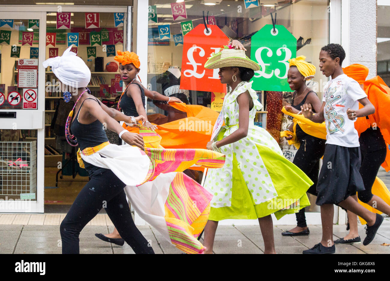 Billingham, north east England, UK, 20th August, 2016. Weather: Dancers from Martinique brighten up a wet Saturday as heavy rain causes the last minute cancellation of the last day parade through Billingham town centre. Credit:  Alan Dawson News/Alamy Live News Stock Photo