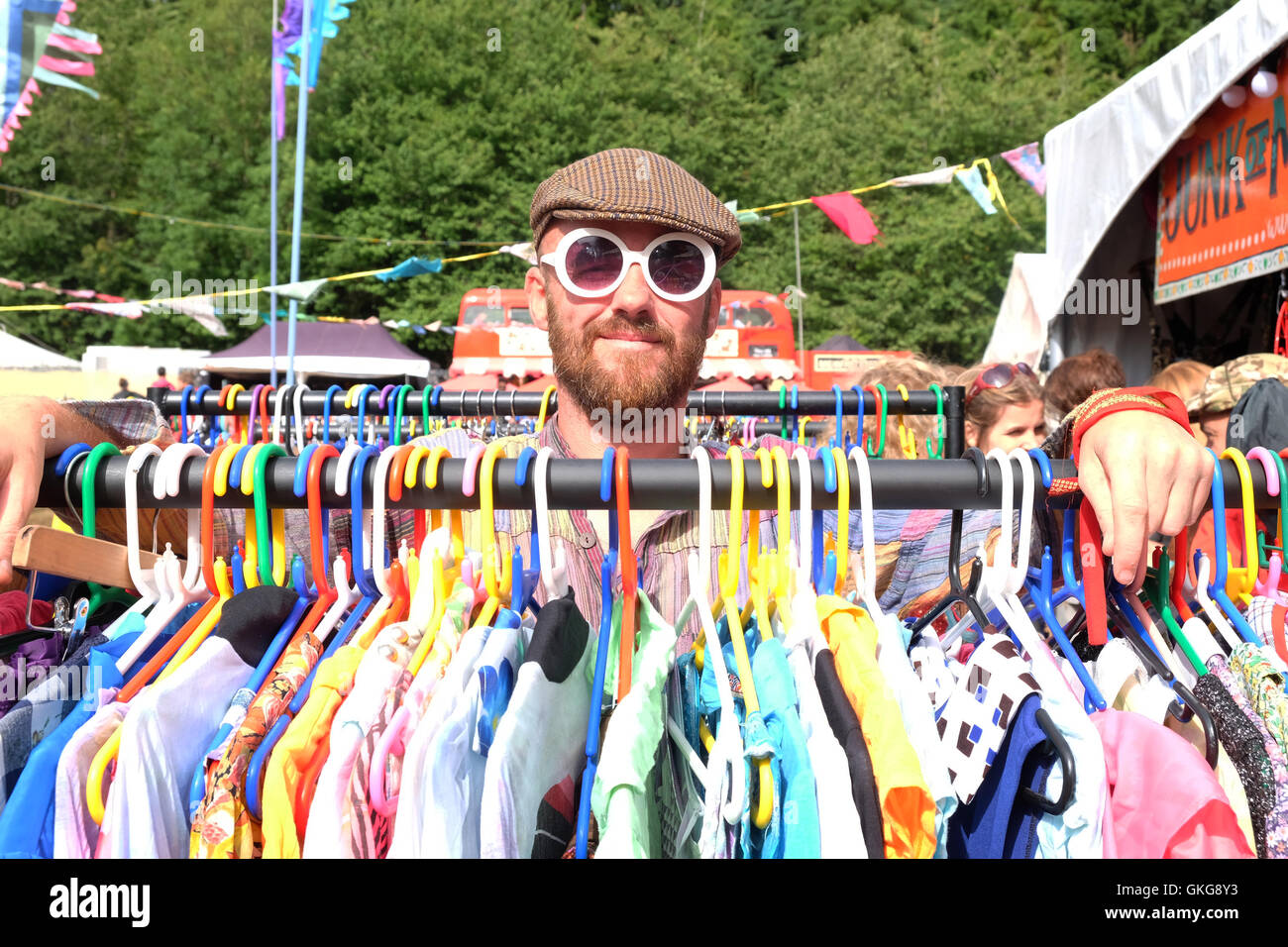 Green Man Festival, Crickhowell, Wales  - August 2016 - Clothes vendor 'Junk of Manchester' poses at the Green Man Festival with his merchandise. Stock Photo