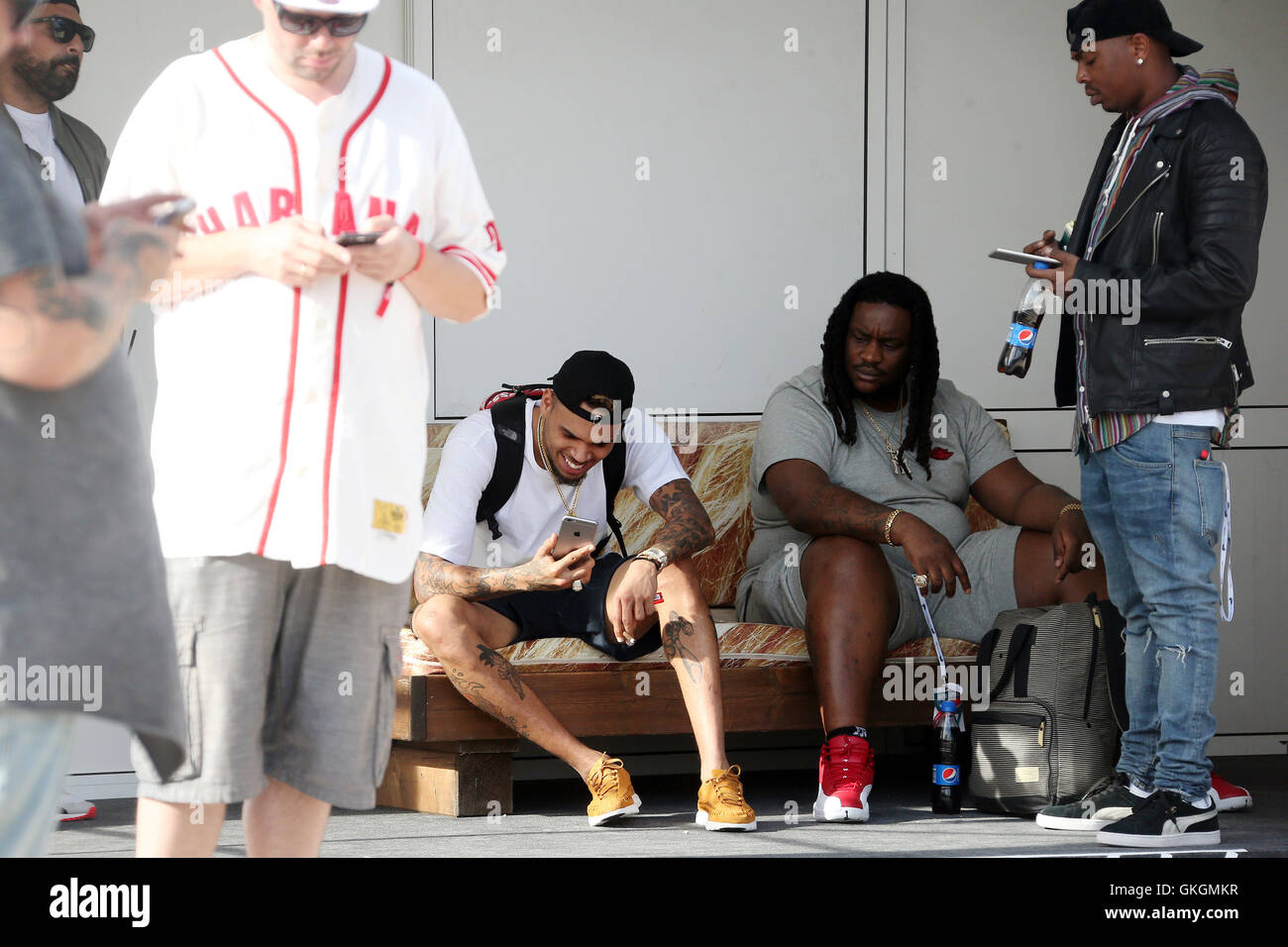 Chris Brown plays with his mobile phone ahead of his performance at the  Fresh Island Festival 2016 in Novalja, Croatia. Chris, who is all smiles,  is also spotted smoking a hand-rolled cigarette