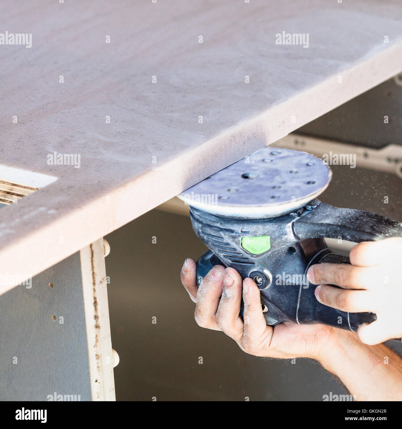 installing new tabletop on kitchen worker polishing worktop from