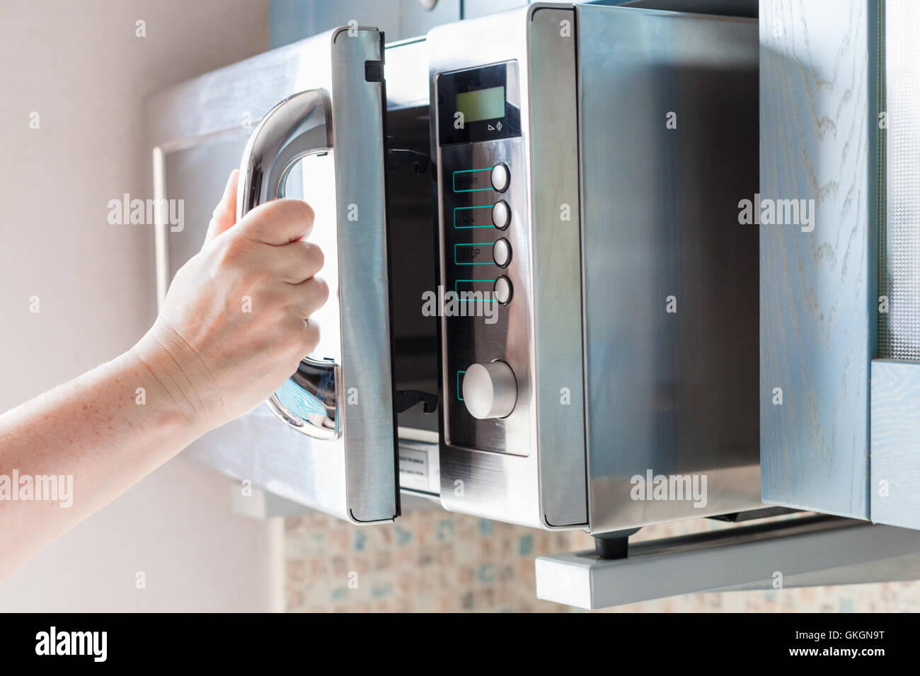 hand opens door of microwave oven for heating food Stock Photo Alamy