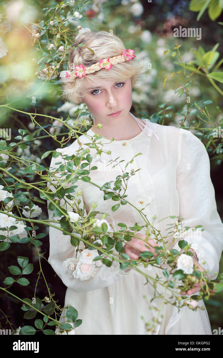 Beautiful fairy girl in roses garden. Fantasy and romantic portrait Stock Photo