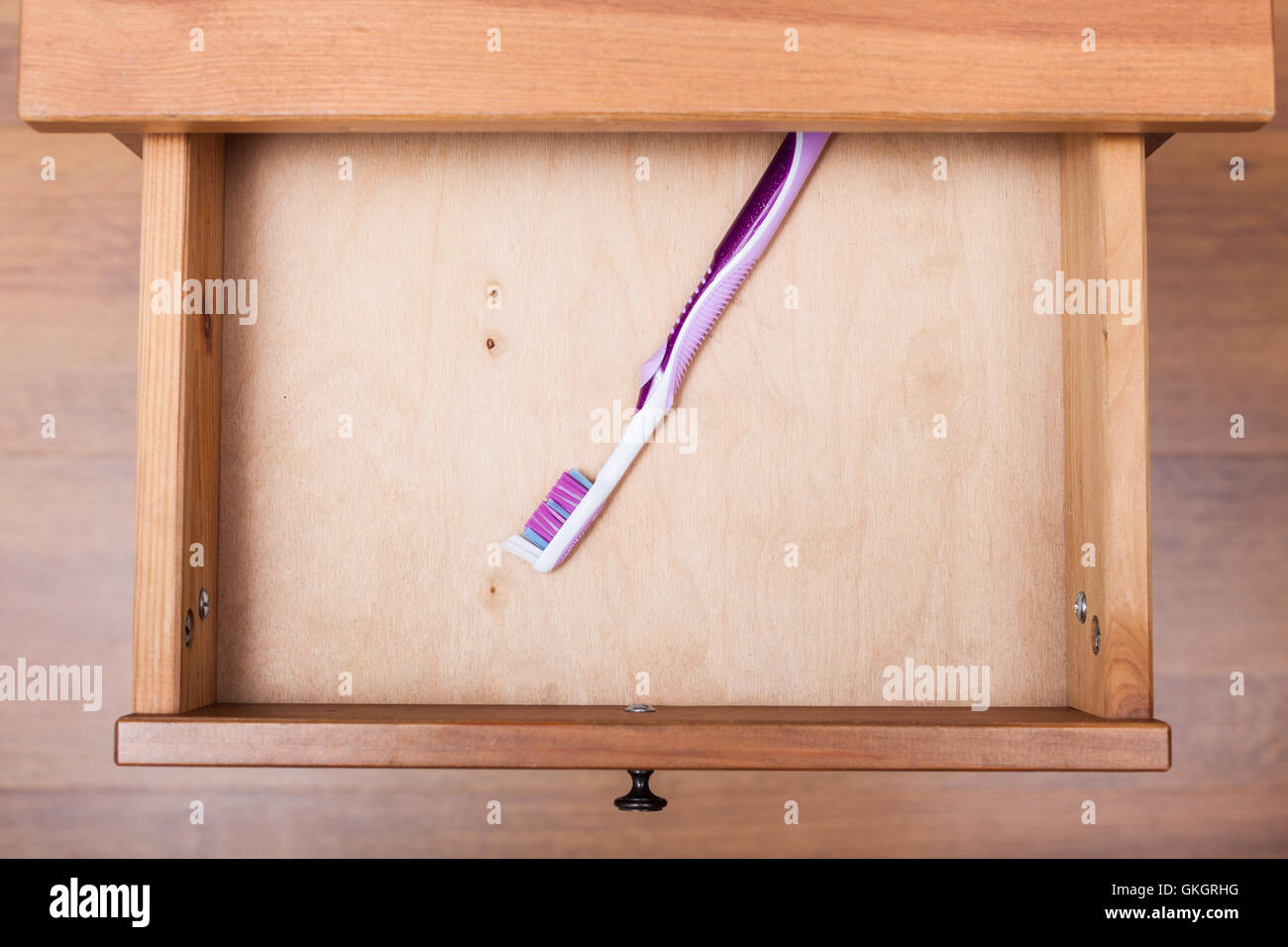 top view of toothbrush in open drawer of nightstand Stock Photo