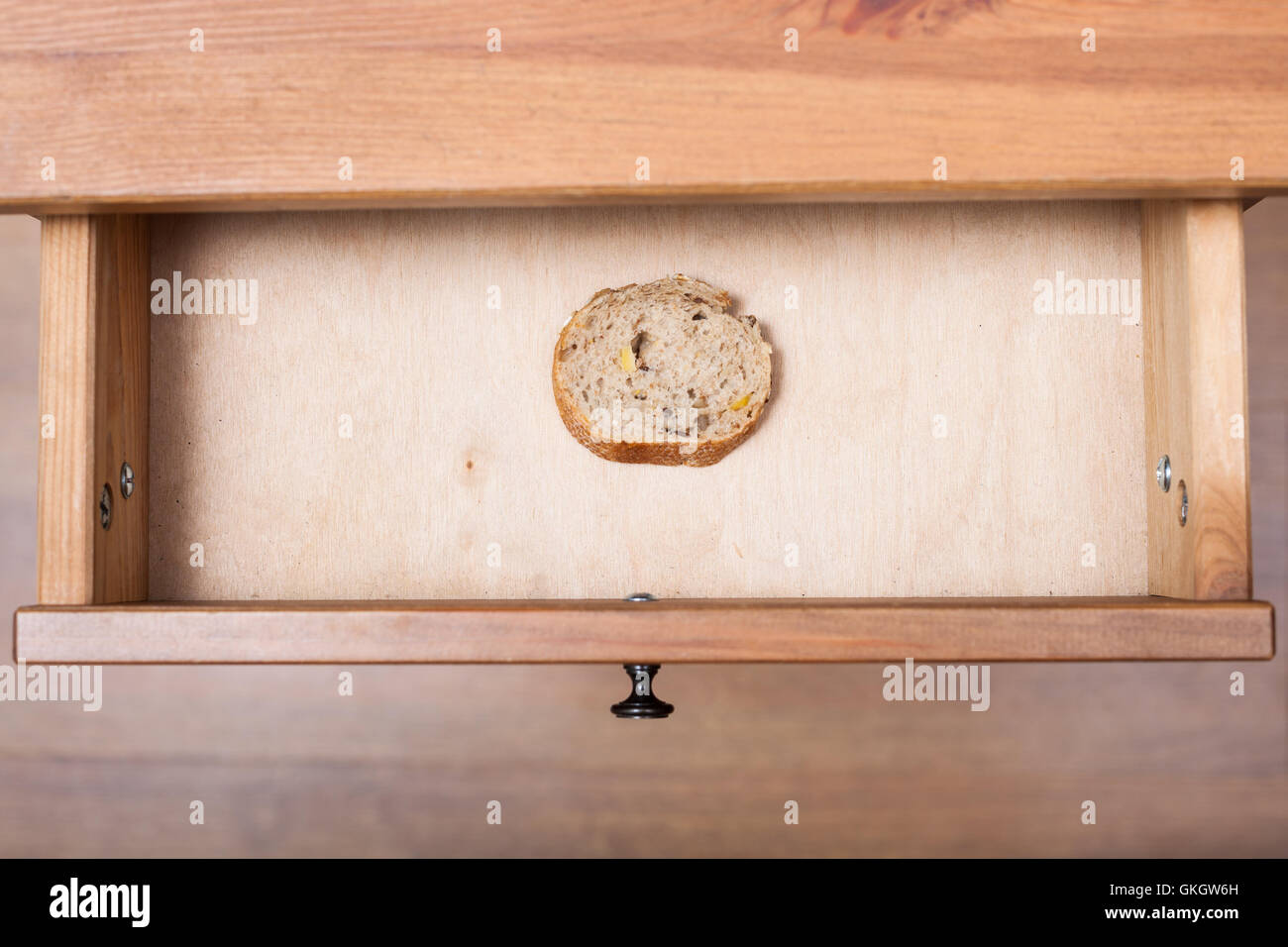 top view of slice of bread in open drawer of nightstand Stock Photo