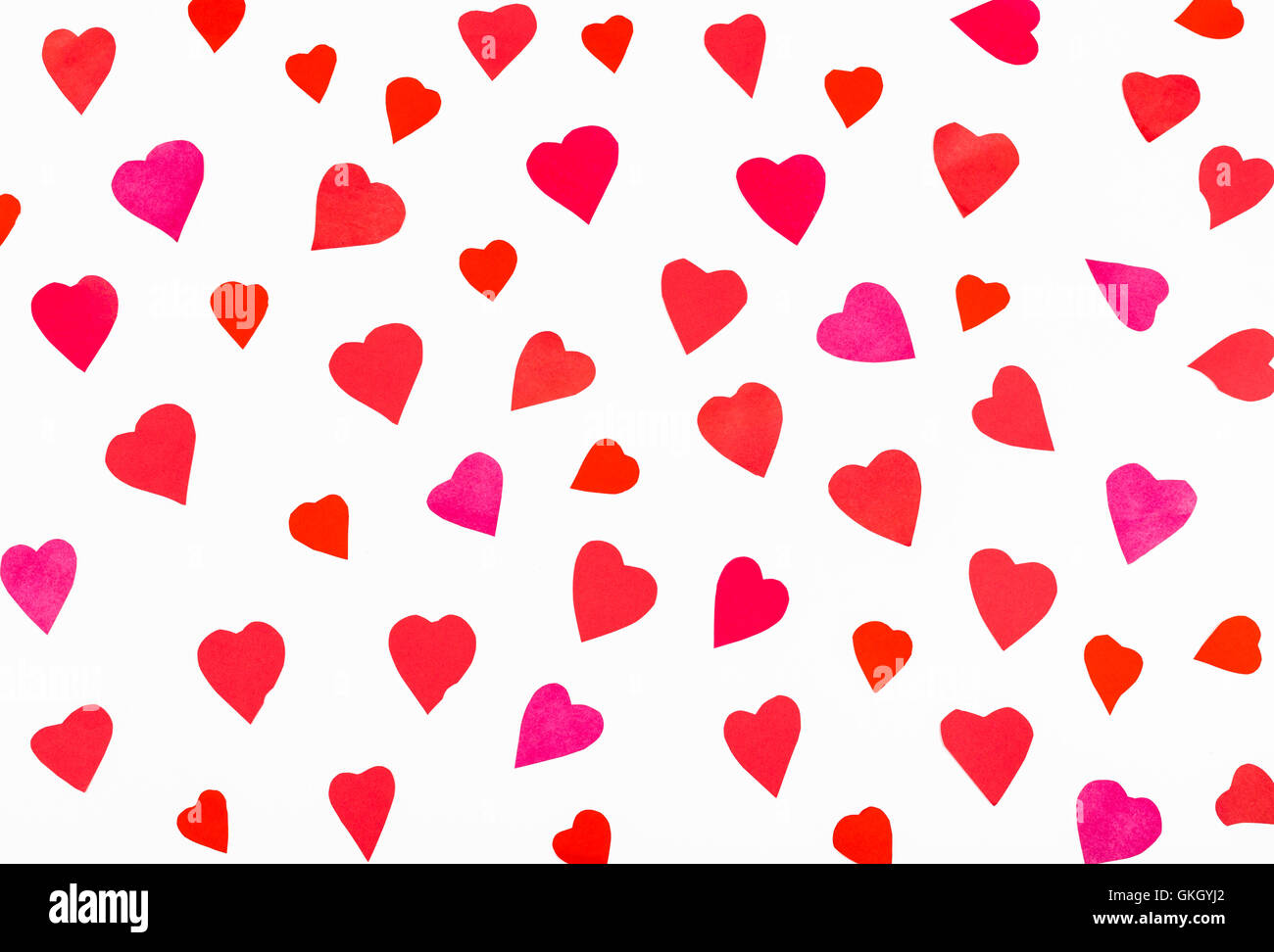 many pink and red hearts carved from paper on white background Stock Photo
