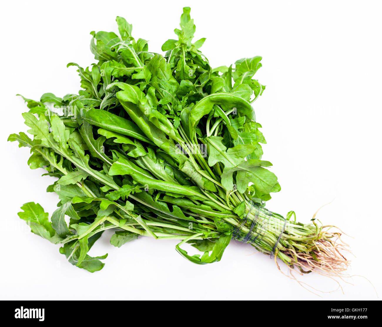 bunch of fresh cut green salad rocket herb on white background Stock Photo