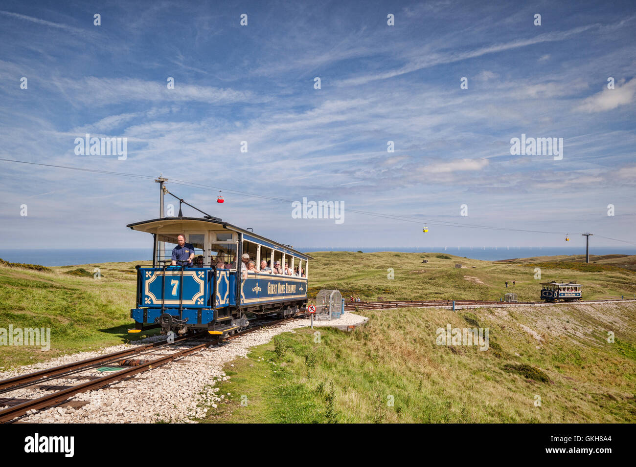 A passenger car of the Great Orme Tramway climbs from the upper passing loop as the descending car continues down, on Great Orme Stock Photo