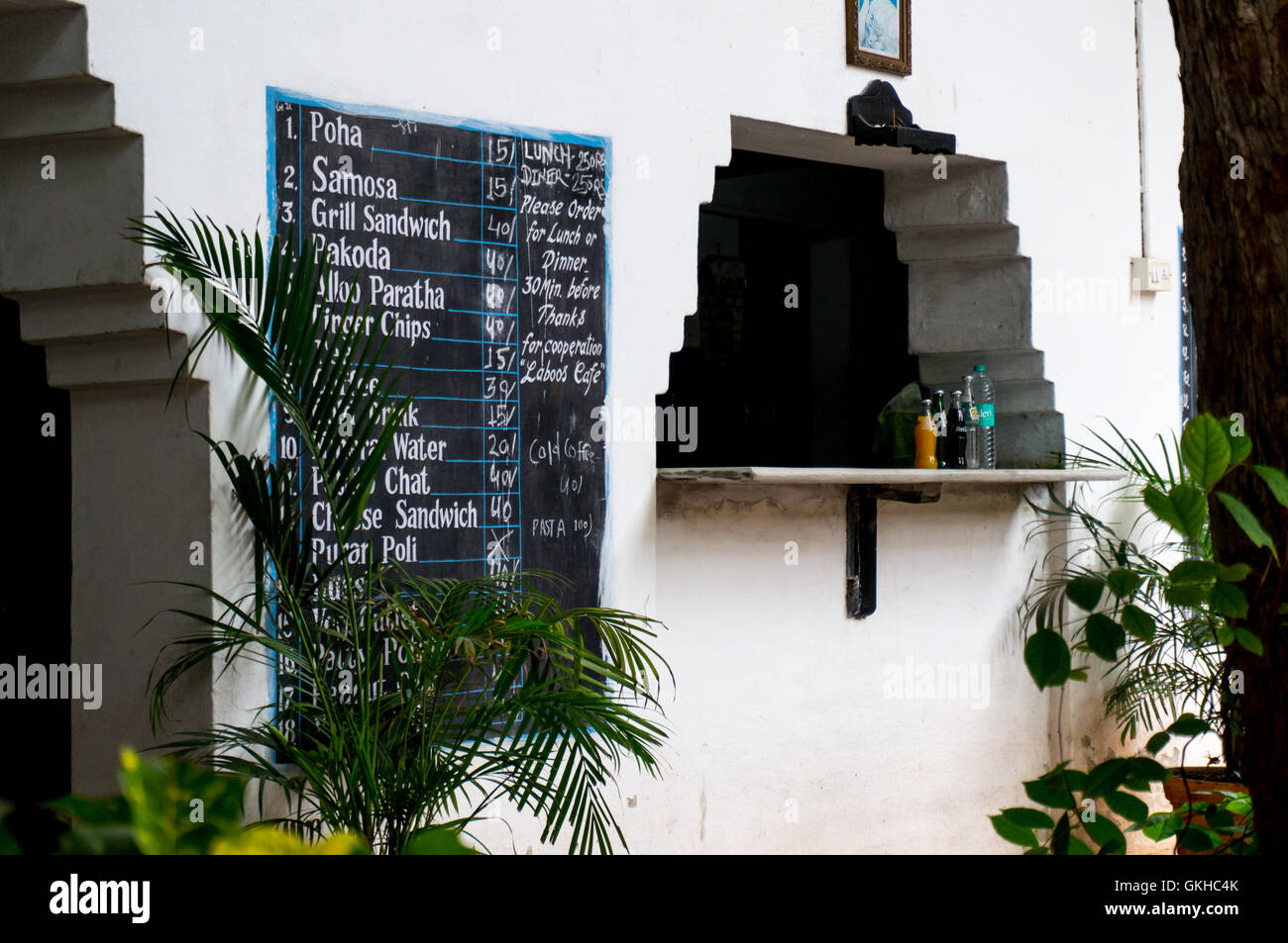 Window with a menu painted on wall at a roadside hotel in india. Places ...