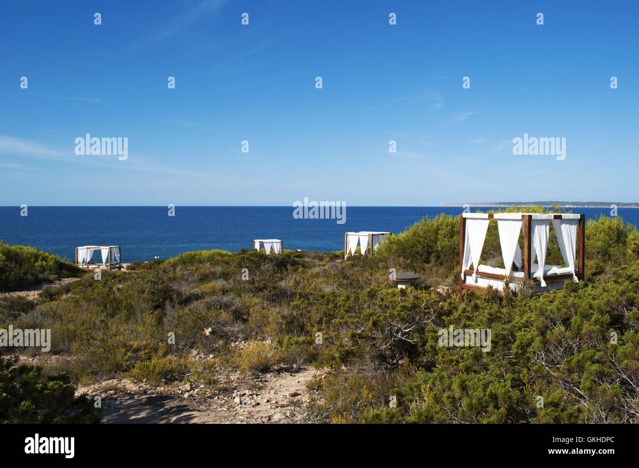 Fomentera, Balearic Islands: sun canopies and white curtains and view on the Mediterranean maquis and the Mediterranean Sea Stock Photo