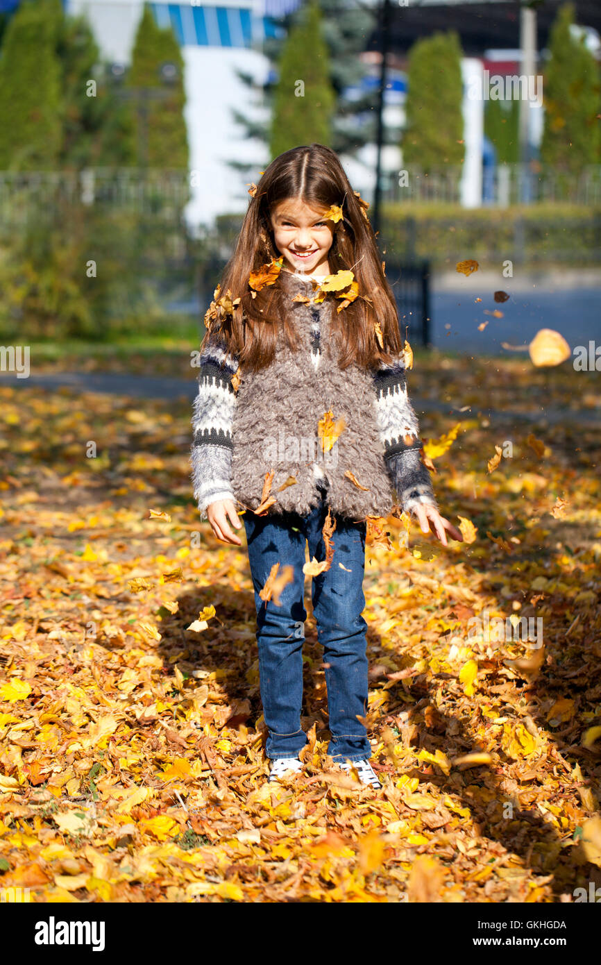 Young beautiful little girl with yellow leaves in autumn park Stock ...