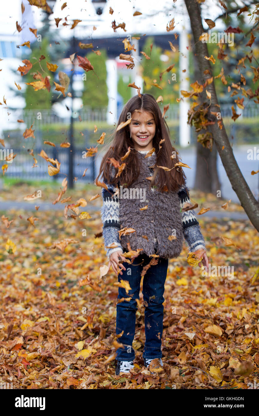 Young beautiful little girl with yellow leaves in autumn park Stock ...