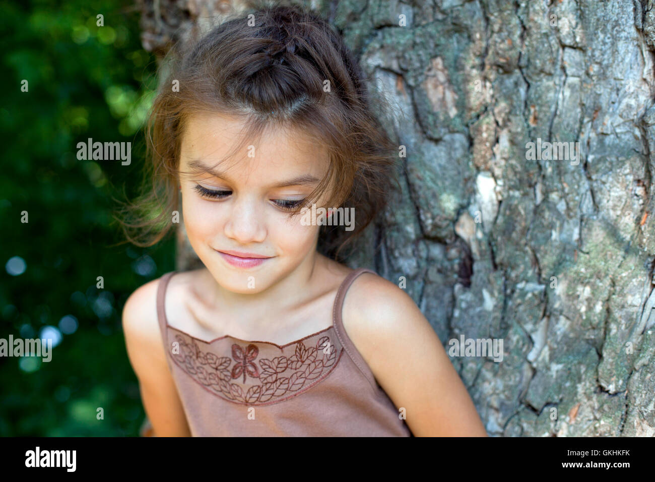 Portrait of beautiful little girl, against background of summer park Stock Photo