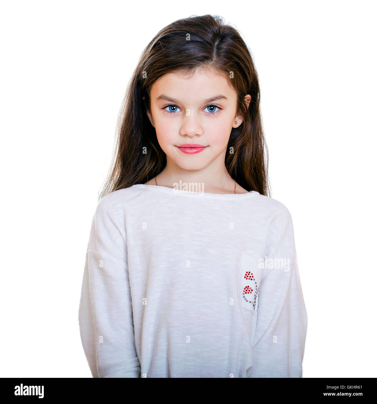 Portrait of a charming little girl smiling at camera, isolated on white ...
