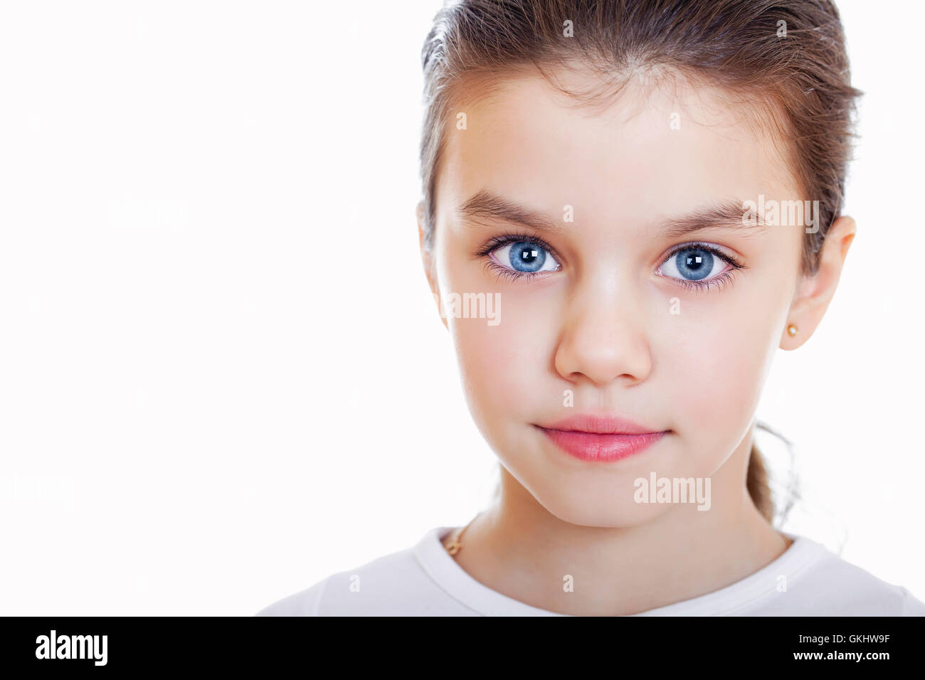 Portrait of a charming little girl smiling at camera, isolated on white ...