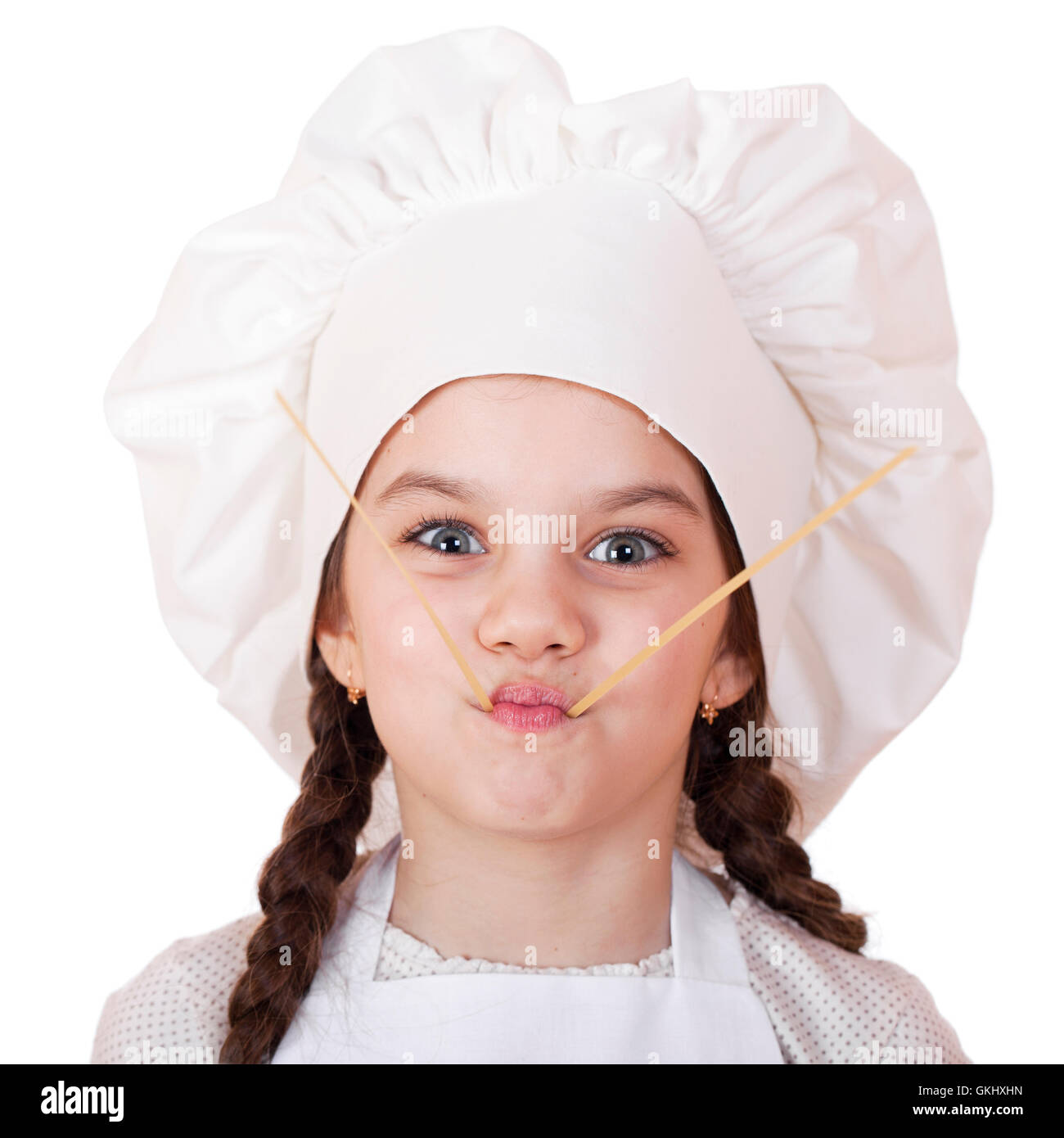 Portrait of a little girl in a white apron and spaghetti, isolated on white background Stock