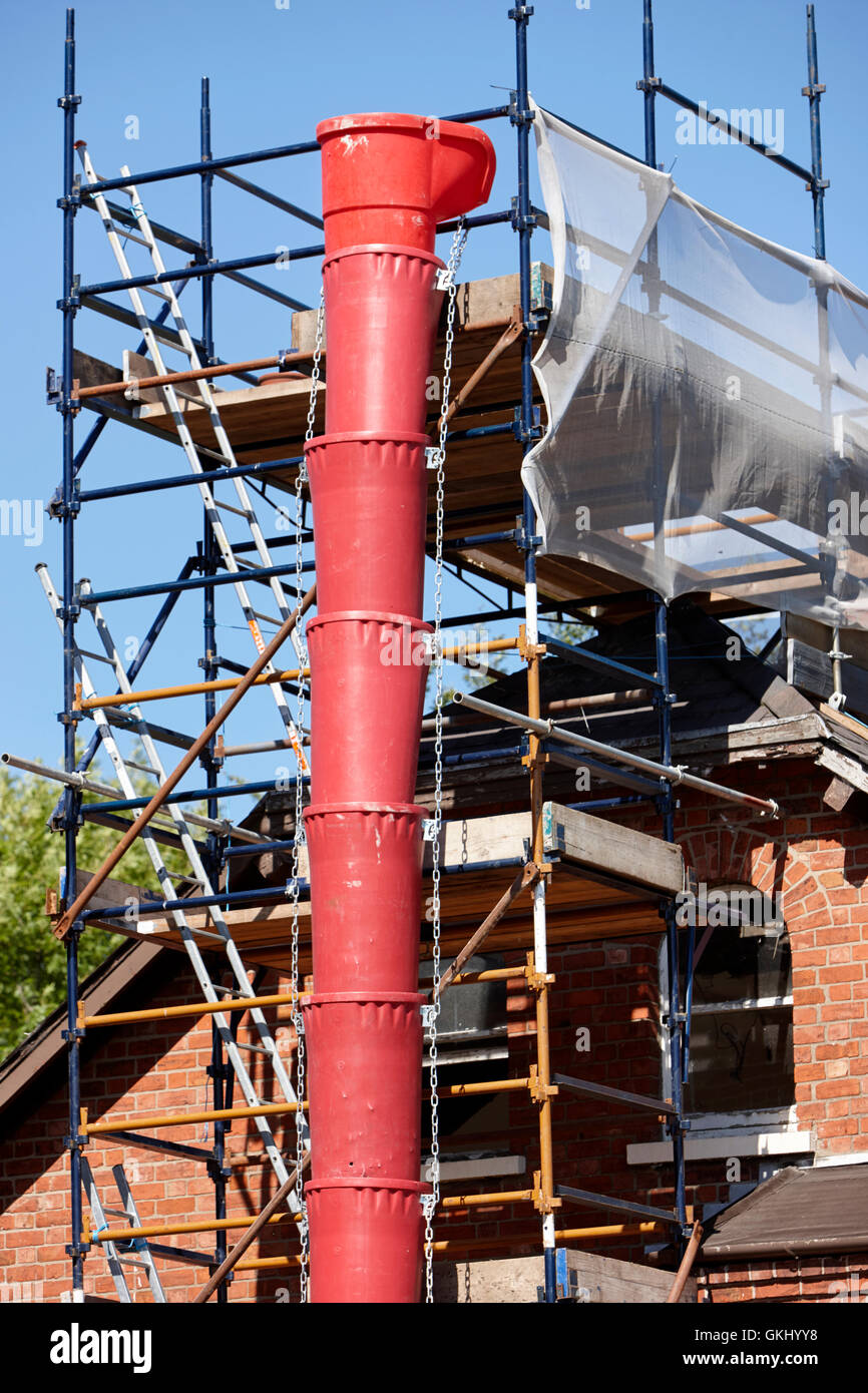 plastic rubbish chute attached to scaffolding on house extension in the uk Stock Photo