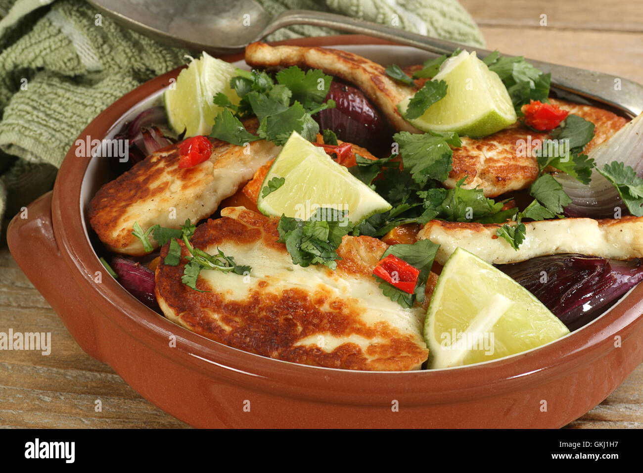 grilled halloumi with red onion and sweet potato in a terracotta bowl Stock Photo