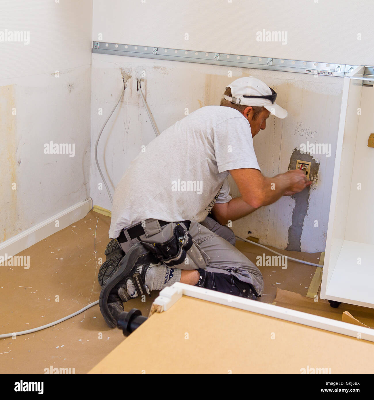 Carpenter mounting an IKEA kitchen Stock Photo