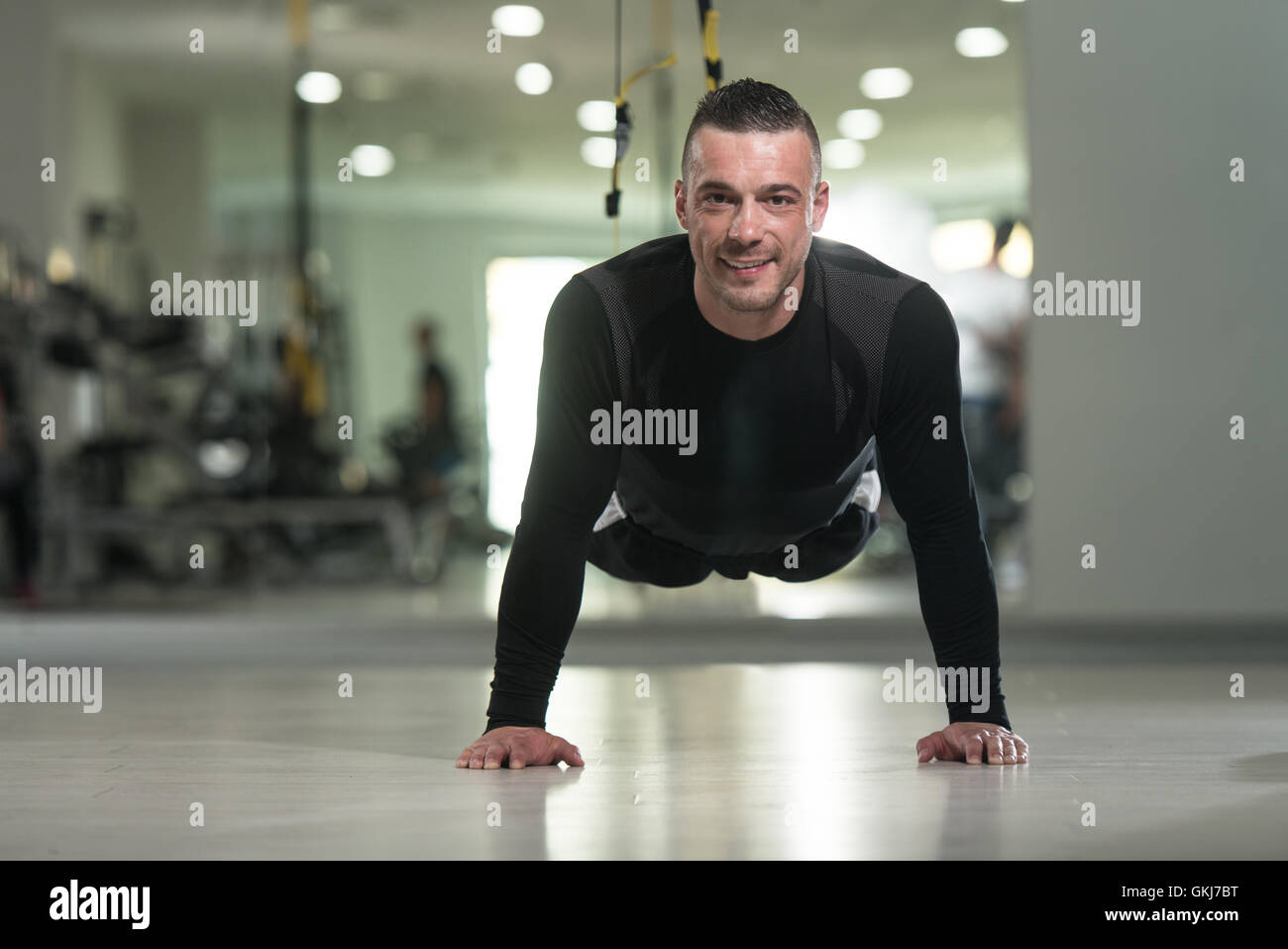 Young Adult Athlete Doing Push Ups With Trx Fitness Straps As Part Of ...