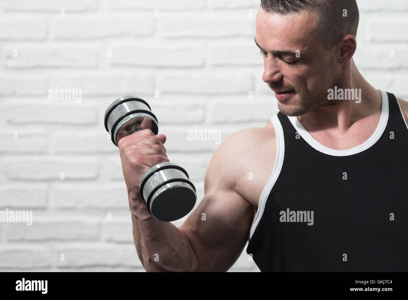 Young Man Working Out Biceps With Dumbbells On White Bricks Background With Copyspace Dumbbell Concentration Curls Stock Photo Alamy
