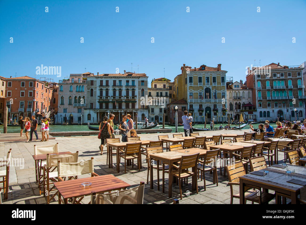 Venice,Italy-August 17,2014:people stroll or take a rest near the bar and restaurant on Grand canal near the Rialto bridge  duri Stock Photo