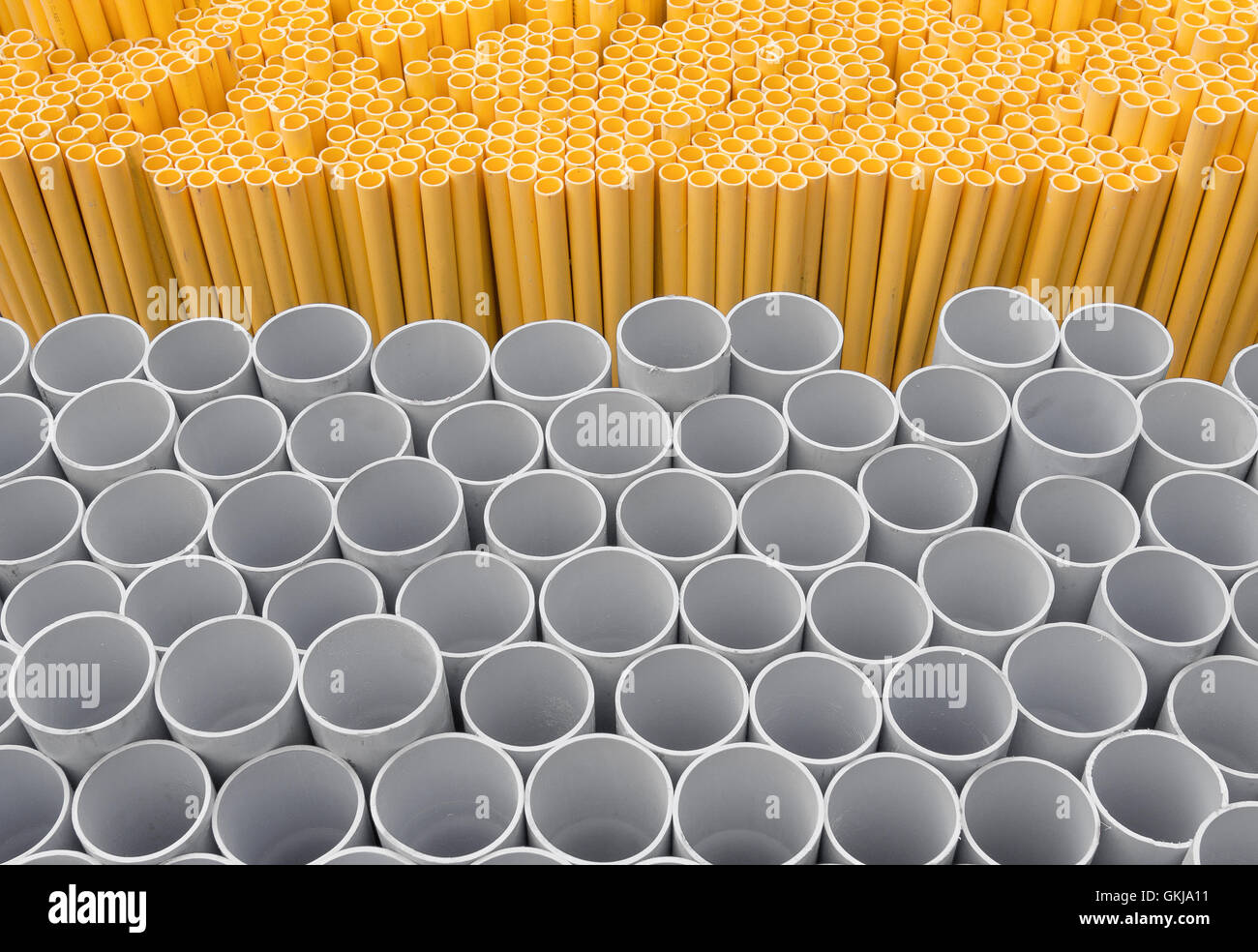 PVC pipes stacked in warehouse, Yellow pipe for electrical wiring and telephone cable conduit. Stock Photo