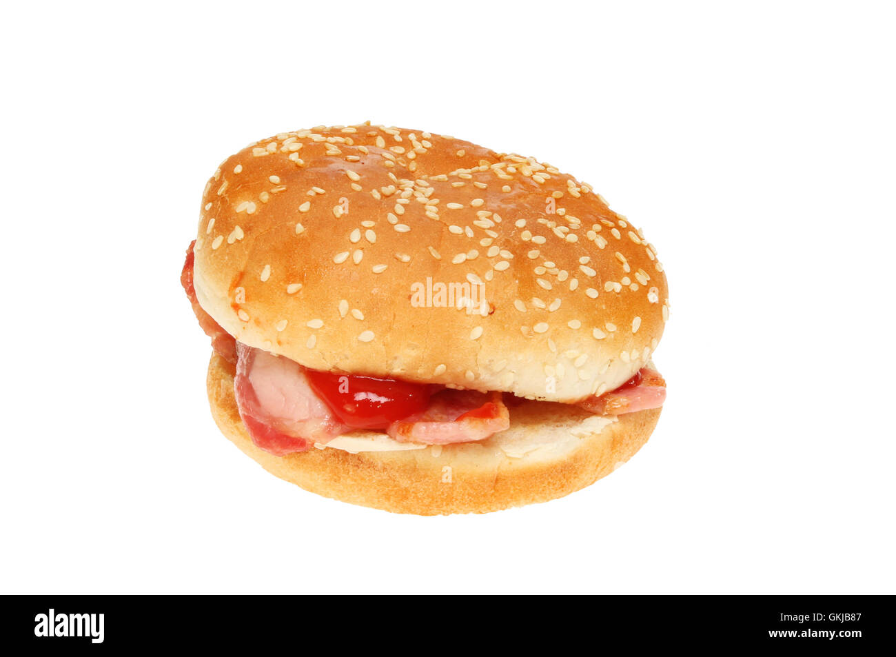Bacon with tomato ketchup in a sesame seeded bun isolated against white Stock Photo