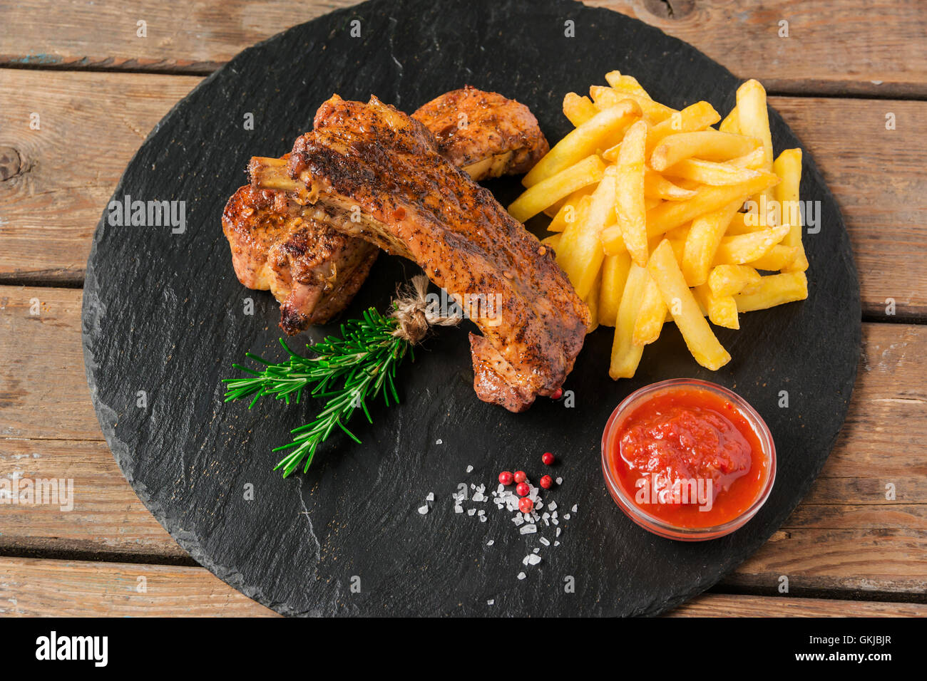 baked pork ribs with french fries and red sauce Stock Photo