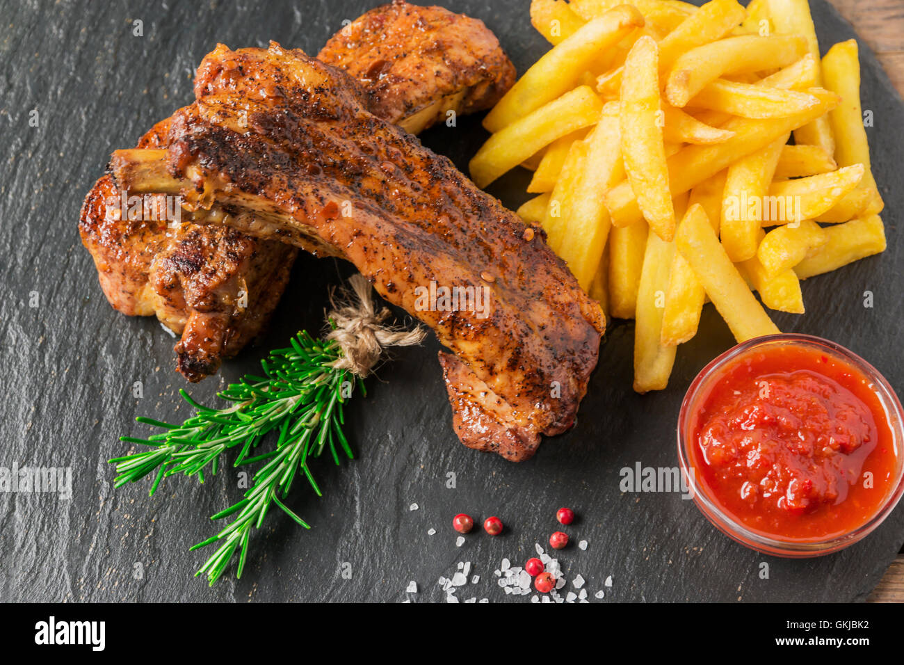 baked pork ribs with french fries and red sauce Stock Photo