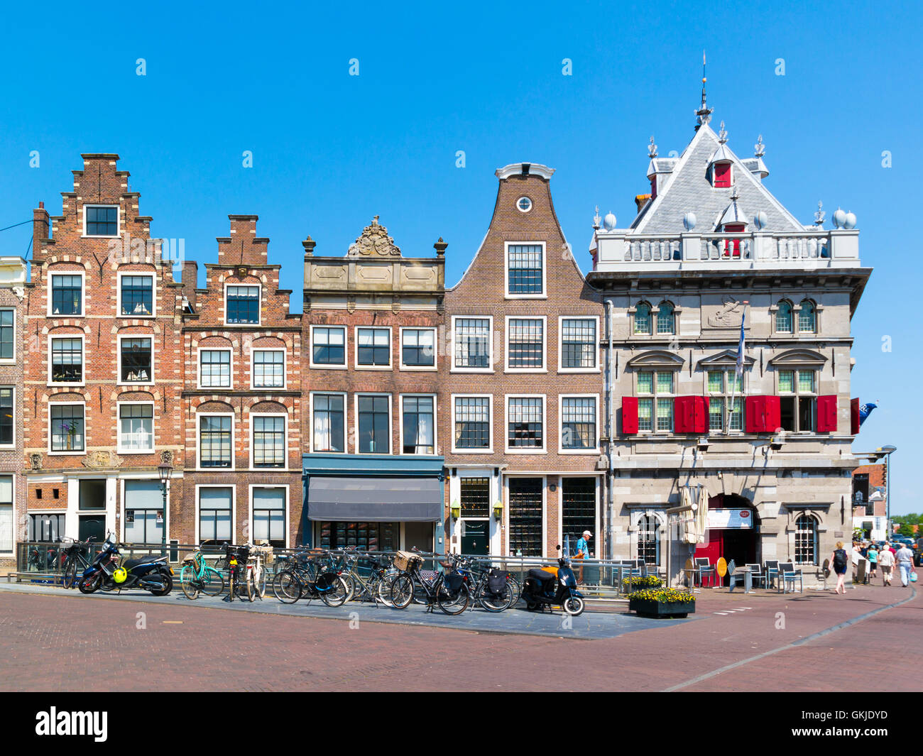 People walking, row of old houses and Waag on Damstraat in Haarlem, Holland, Netherlands Stock Photo