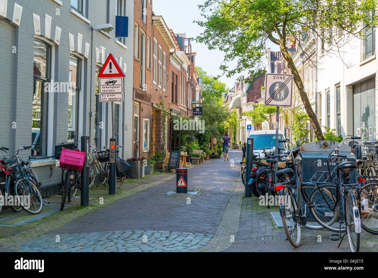 Parked bicycles and flexible bollard for vehicle access control in Breestraat street in city centre of Haarlem, Netherlands Stock Photo
