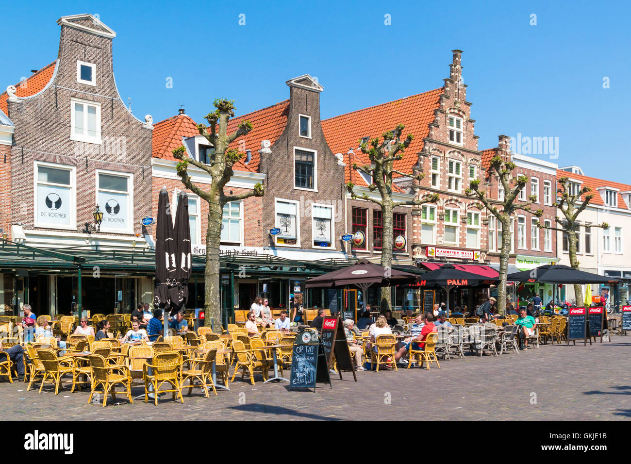 People enjoying vacation on outdoor sidewalk cafes on Botermarkt square in old town of Haarlem, Holland, Netherlands Stock Photo