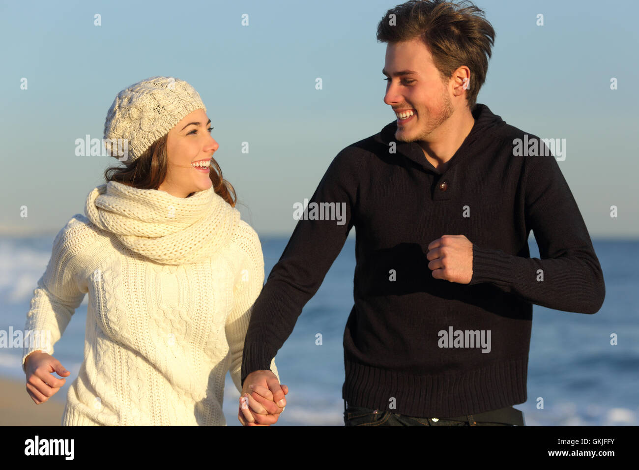 Couple running on the beach in winter Stock Photo