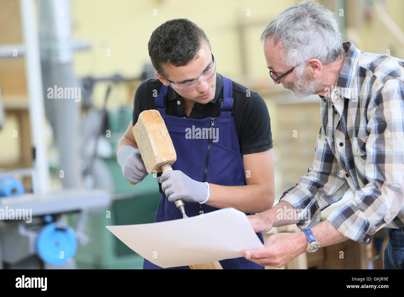 Young apprentice with teacher working on piece of wood Stock Photo Alamy