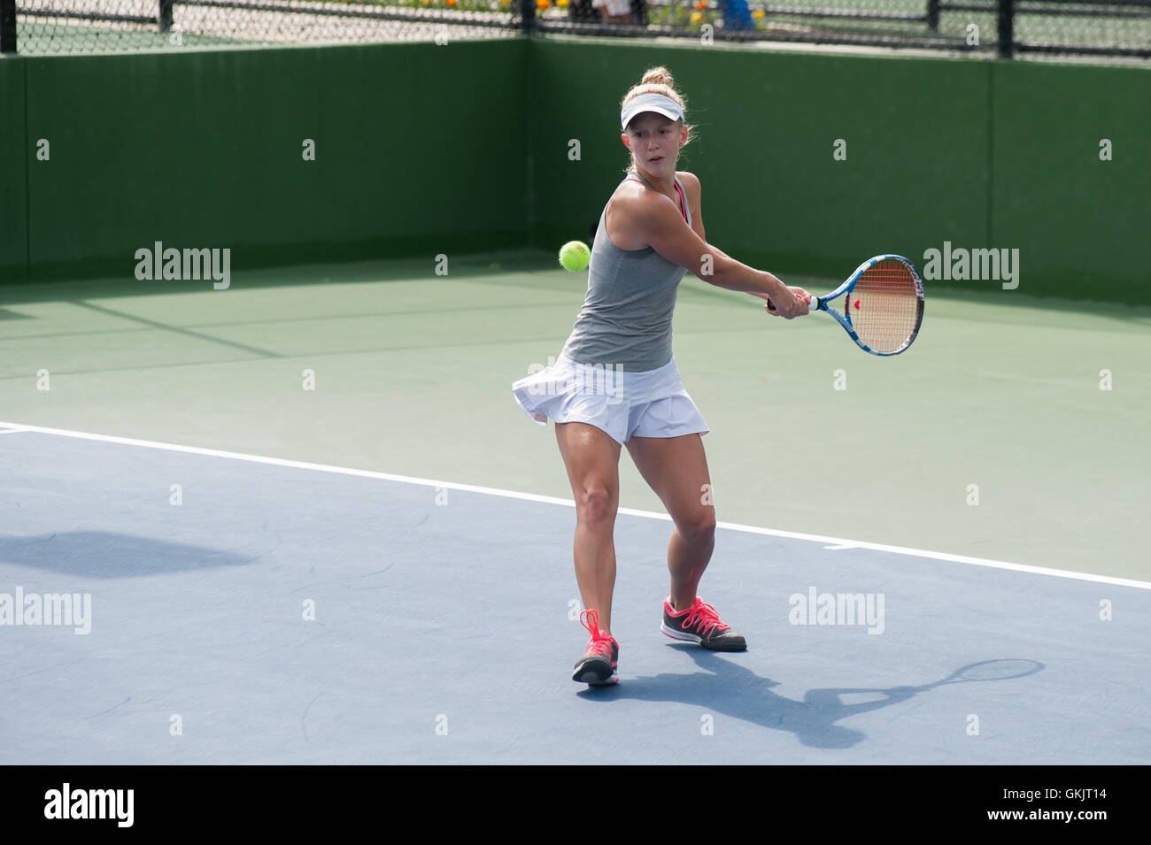 Female tennis athlete ready to hit a two handed backhand Stock Photo