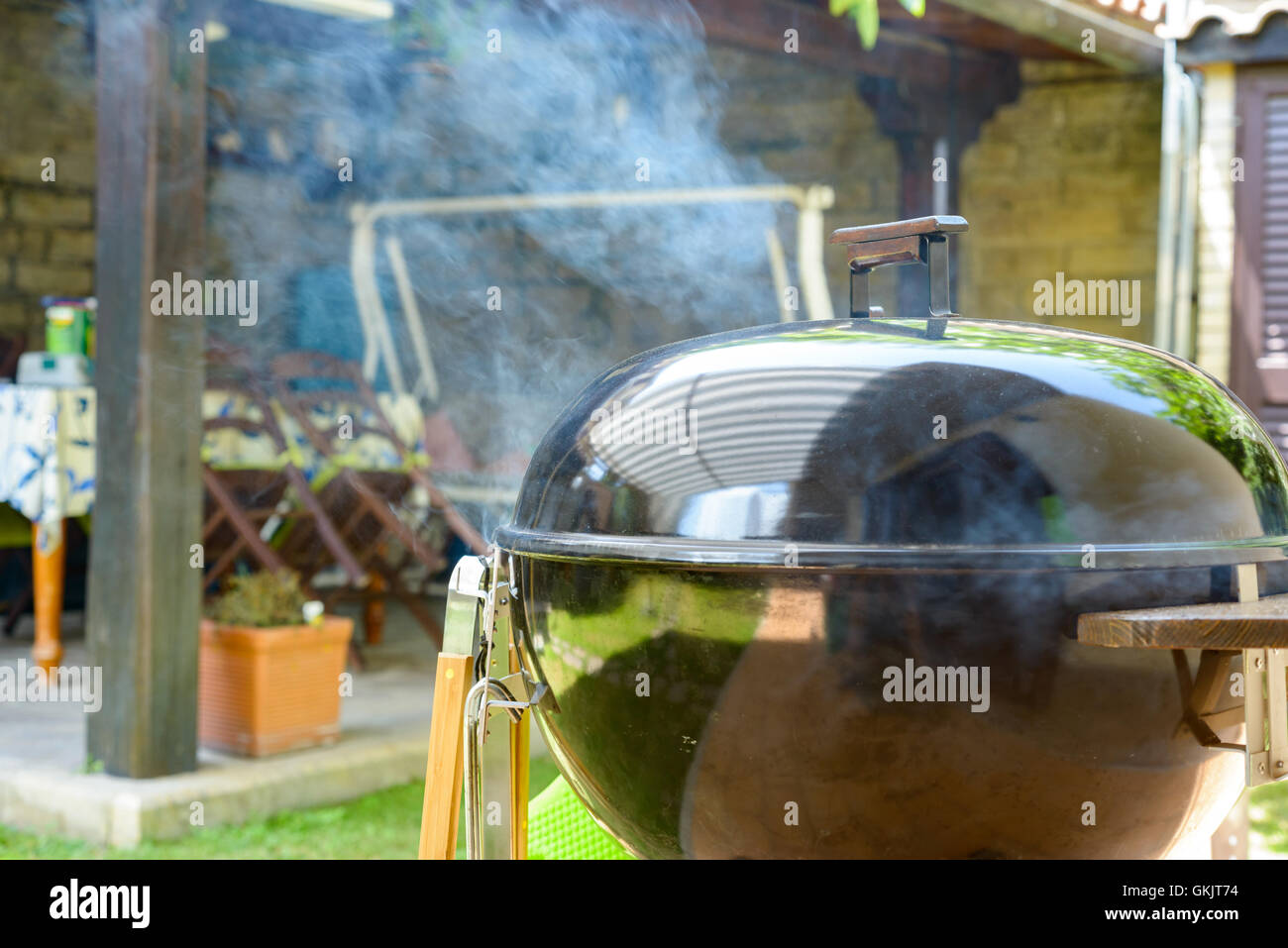 Smoke go out from a closed barbecue during pulled pork grill Stock Photo