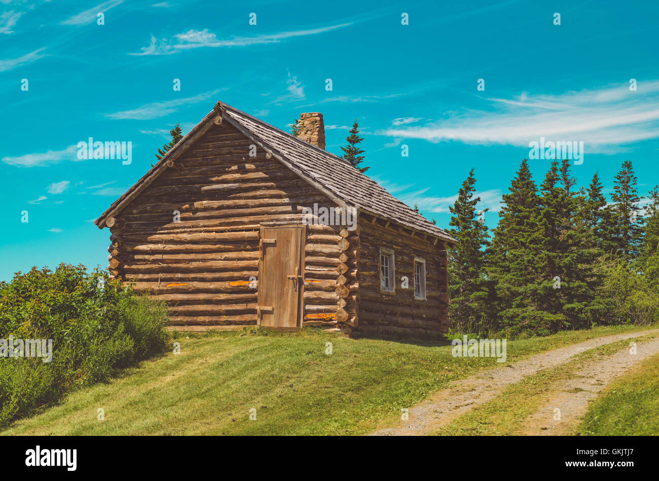 An old log cabin on a hilled forest in Canada. Color graded to give a classic Technicolor look from the late 50s. Stock Photo